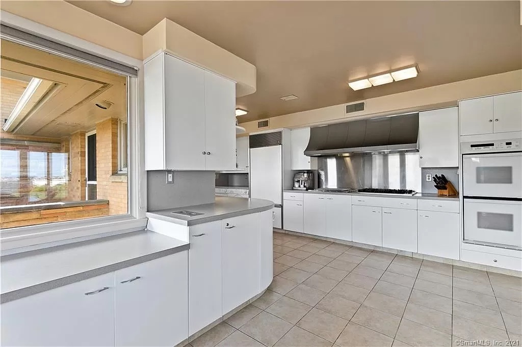 Outdated kitchen with worn flooring and traditional cabinetry before renovation
