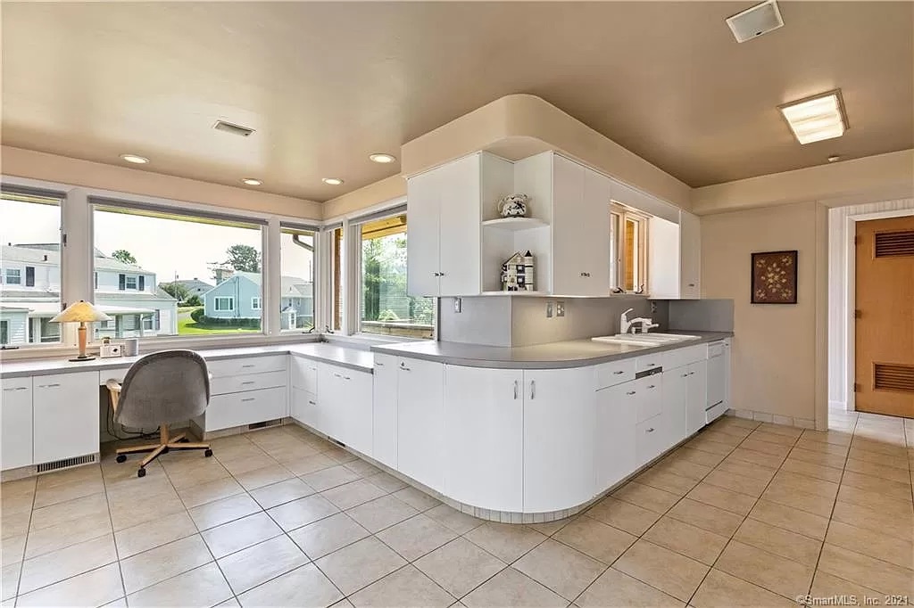 Kitchen sink and countertop area before renovation with dated fixtures.