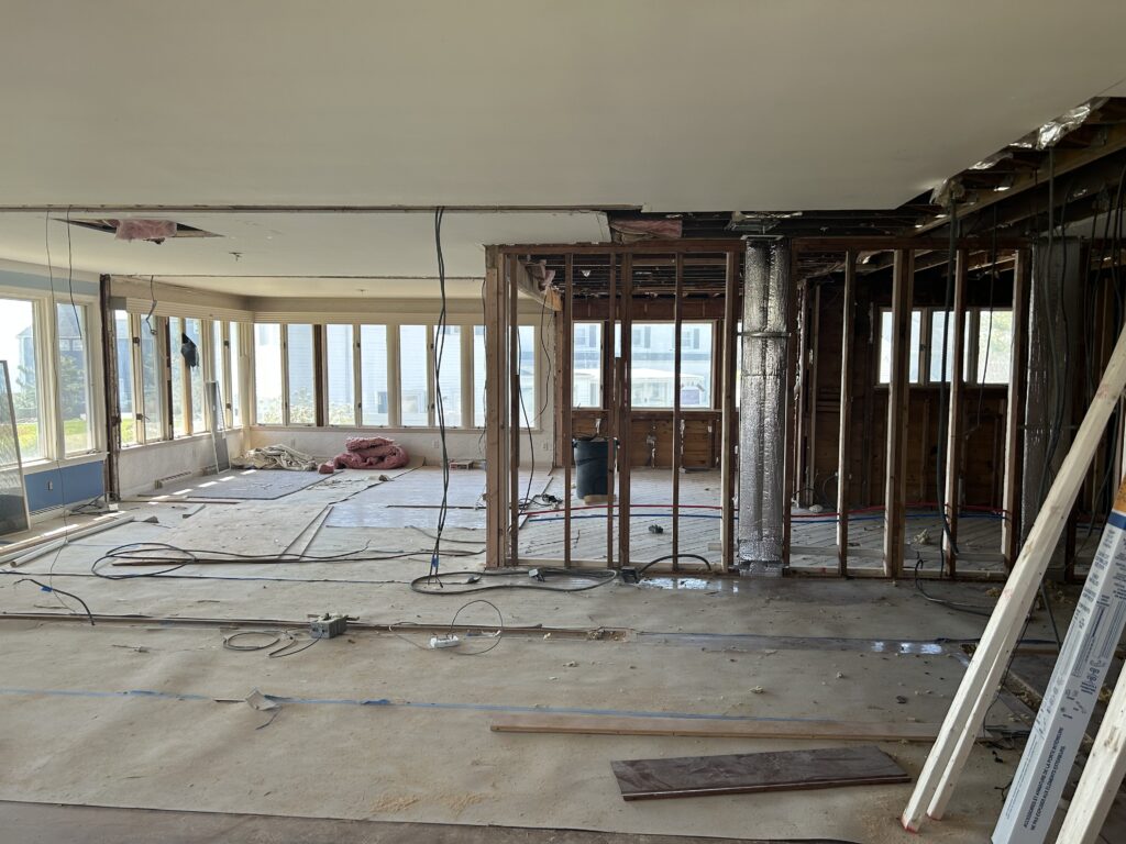 Kitchen renovation in progress showing installation of English green cabinets and walnut accents