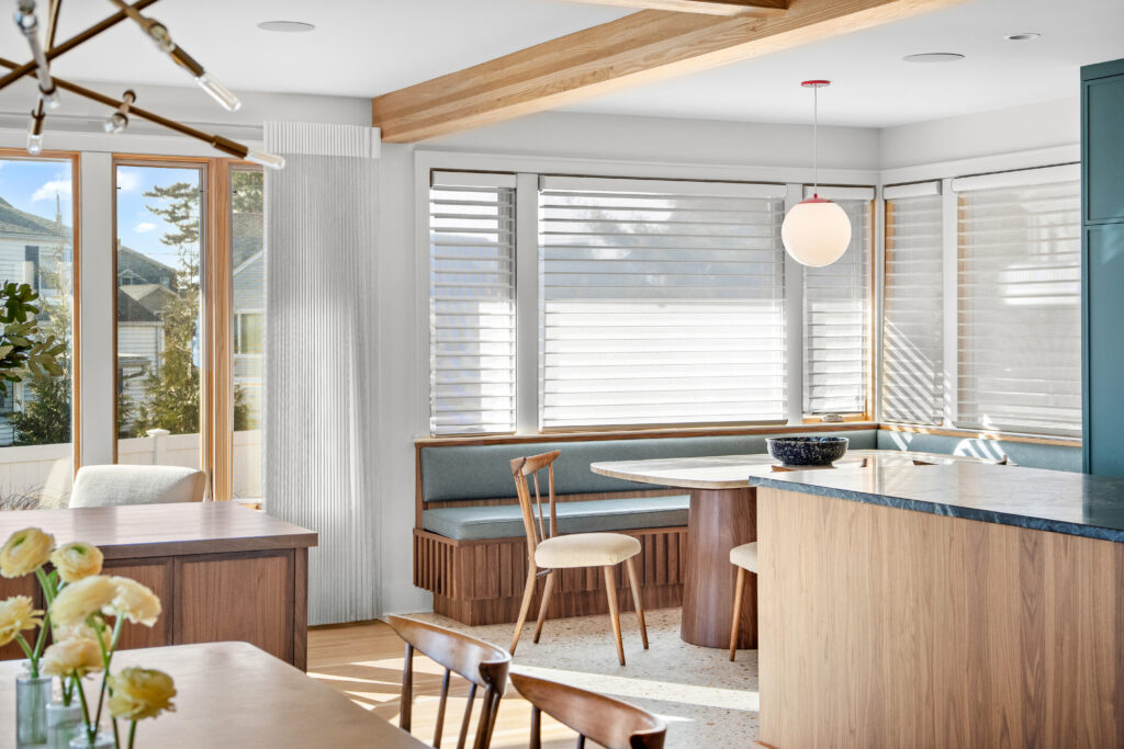 Wide-angle view of renovated kitchen showing cohesive design of cabinetry, flooring, and lighting